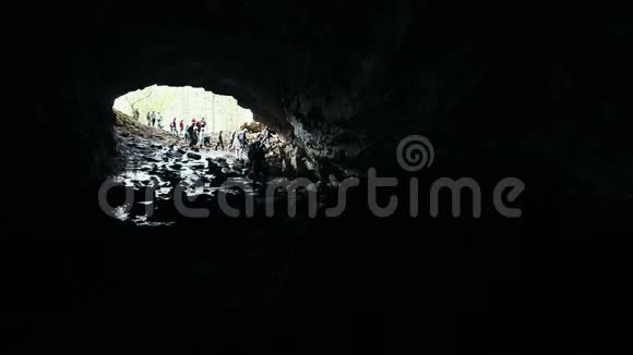 一个潮湿的岩石洞穴在山洞里散步的人视频的预览图
