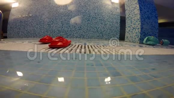 游泳池附近有红色的橡胶拖鞋视频的预览图