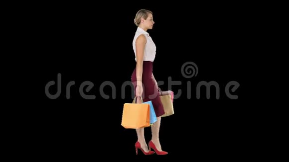 快乐全长的女人手里拿着纸购物袋走着走着阿尔法频道视频的预览图