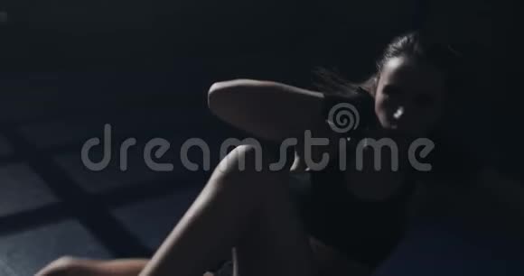 在拳击场上做腹部运动的年轻女子女孩训练剪影视频的预览图