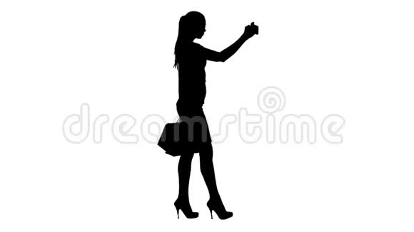 剪影迷人的年轻女人长长的黑发拿着不同的空白购物袋自拍视频的预览图