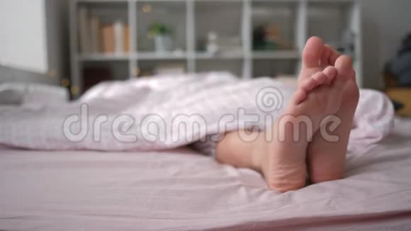躺在柔软的白色枕头上的双脚特写视频的预览图