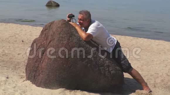 人躲在石头后面用望远镜视频的预览图