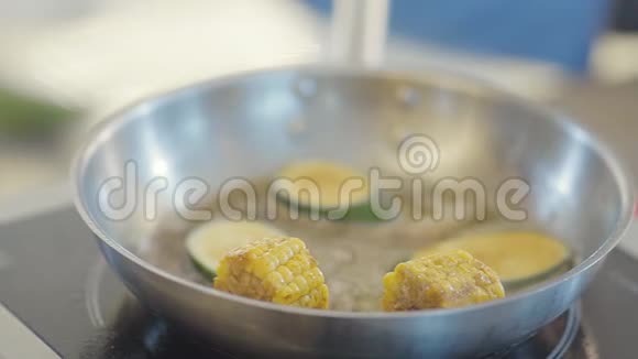 新鲜蔬菜准备在餐厅厨房特写在煎锅上加入多汁玉米和西葫芦视频的预览图
