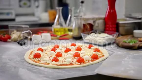餐厅厨房一位厨师把披萨放进烤饼里视频的预览图