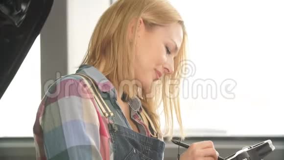 快乐美丽的女孩使用电脑诊断修理汽车视频的预览图