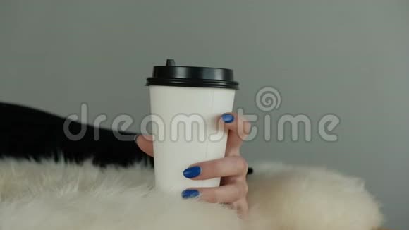 一个年轻的不明身份女孩的手拿着一个纸咖啡杯视频的预览图