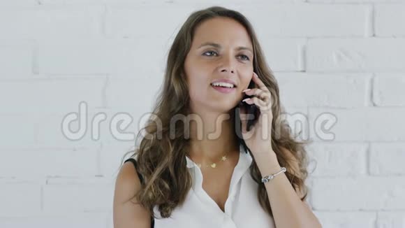 有波浪发的开朗女人在智能手机上讲话视频的预览图