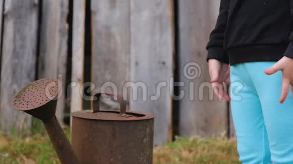 一个身份不明的小孩站在生锈的旧水缸附近视频的预览图