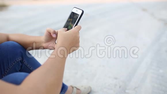女人在她的智能手机上玩游戏视频的预览图