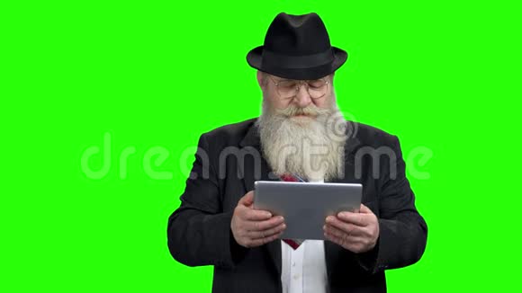 在平板电脑上玩游戏的老商人视频的预览图