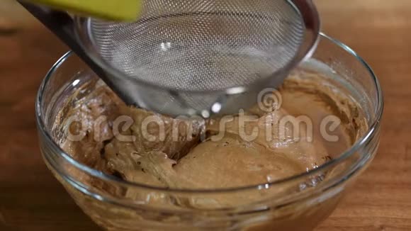 用巧克力面糊把面粉筛入碗中视频的预览图
