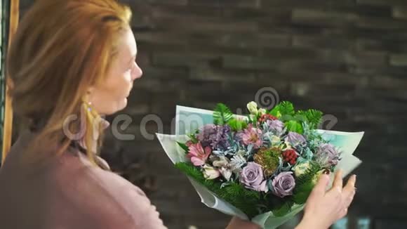 一个穿着围裙的女花店站在花店的柜台上包着一束花视频的预览图