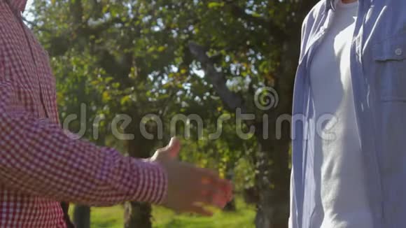 两个面目全非的农民握手准备缔结绿树协议视频的预览图