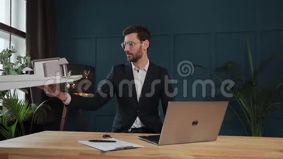 男设计师在办公室与模型屋笔记本电脑工作视频的预览图