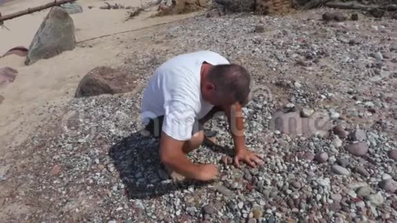 人类在海边为金字塔收集石头视频的预览图