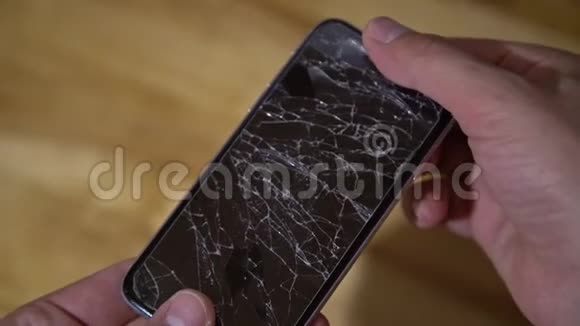 智能手机的概念手持手机的男人手的俯视图手机显示屏破裂破裂破碎的lcdtouc视频的预览图