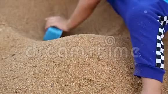 孩子在沙滩上玩玩具特写挖沙子视频的预览图
