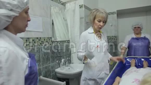 一位女医生向护士解释如何使用创新技术清洗久坐患者4K视频的预览图