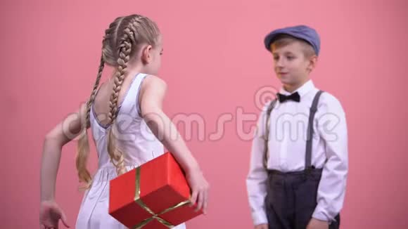 情人节穿着白色连衣裙的小女孩给男朋友送上包装好的礼物视频的预览图