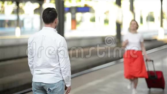 幸福情侣拥抱火车站站台在火车站告别年轻女孩和男人在拥抱视频的预览图