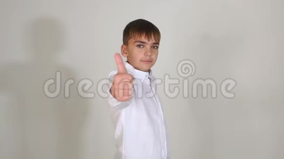 穿白色衬衫的小男孩在工作室里站在白色背景上视频的预览图