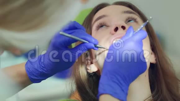 女人张开嘴的脸牙科医生检查病人牙齿视频的预览图