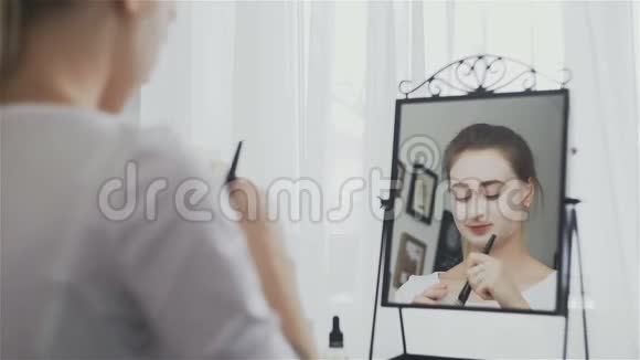 在镜子前的房间里戴化妆面具的女人视频的预览图