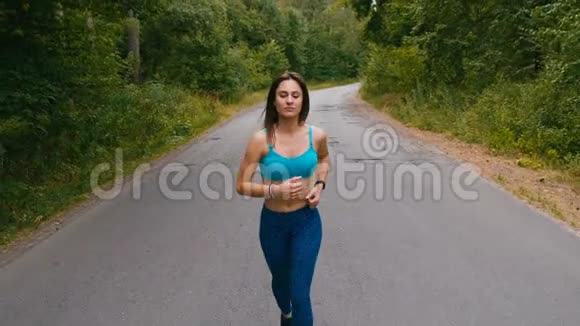 迷人的年轻女子在夏季森林或公园跑步女孩慢跑户外红心跑视频的预览图