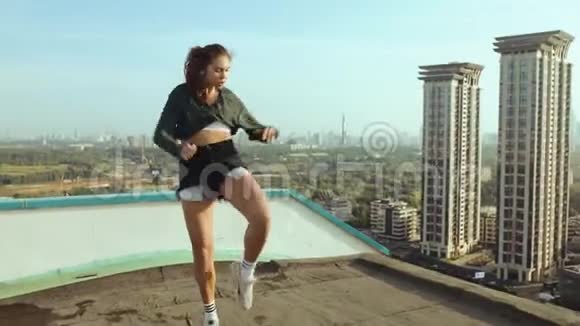 一个年轻迷人的女人正在日出的背景下与城市景观一起跳舞和伸展自由视频的预览图