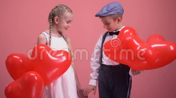 可爱的小情侣手拿气球面带微笑孩子们在约会视频的预览图