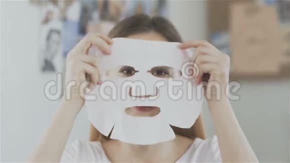 女人在脸上戴着日本化妆面具照镜子视频的预览图