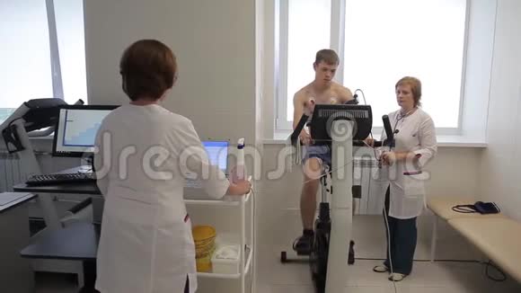 一组医生用一辆运动自行车进行心电图检查4K视频的预览图