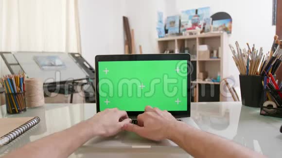 设计师的观点是在一台绿色屏幕的笔记本电脑上工作视频的预览图