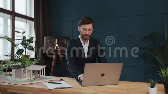 男设计师在办公室与模型屋笔记本电脑工作视频的预览图