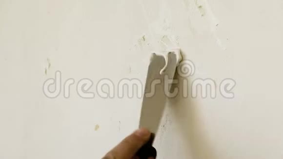 修理工的男手用刮刀将浆糊涂在墙上密封孔现代技术修复视频的预览图