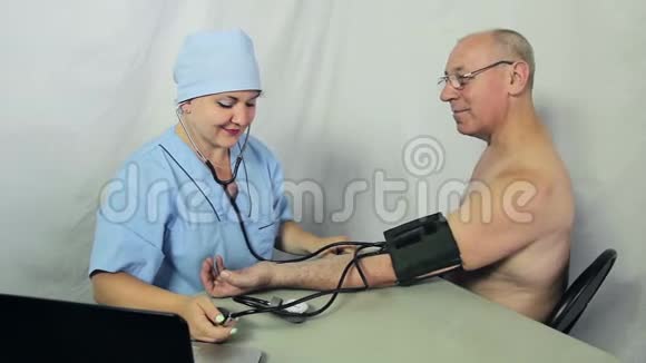 一位女医生坐在他的办公桌前从病人的手臂上拿出一量计摄像机移动到杜莉视频的预览图