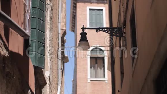 在狭窄的威尼斯街道上挂着一盏挂在墙上的路灯视频的预览图