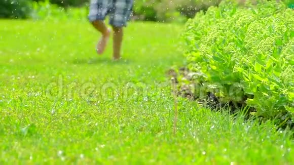 赤脚男孩跑在新鲜的绿草慢动作孩子玩得开心夏天大自然快乐的童年视频的预览图