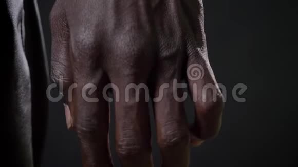 黑色男人血管和强壮的手美丽的肌肉身体黑色工作室背景的近距离移动镜头视频的预览图