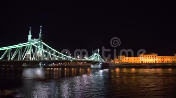 靠近自由桥的多瑙河上的一艘船在夜间照明视频的预览图