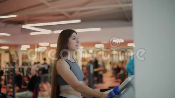 非常漂亮的女人在健身房和饮用水的跑步机上锻炼视频的预览图