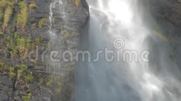 在明亮的阳光下的棕色岩石悬崖高瀑布视频的预览图
