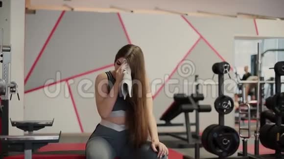 非常漂亮的女人在健身房锻炼后擦汗视频的预览图