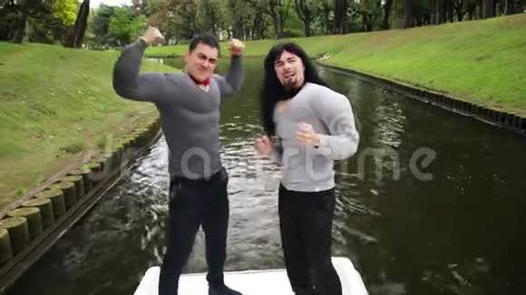 两个穿着假肌肉服装的帅哥在船上唱歌跳舞视频的预览图