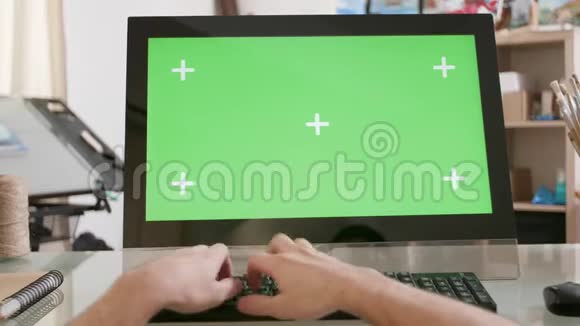 年轻的艺术家手在绿色屏幕前的键盘上打字视频的预览图