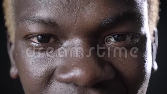 摄影棚黑色背景快乐的非洲裔美国人的眼睛看着镜头视频的预览图