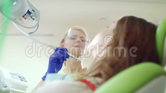 牙科诊所从事专业牙齿清洁的女牙医视频的预览图