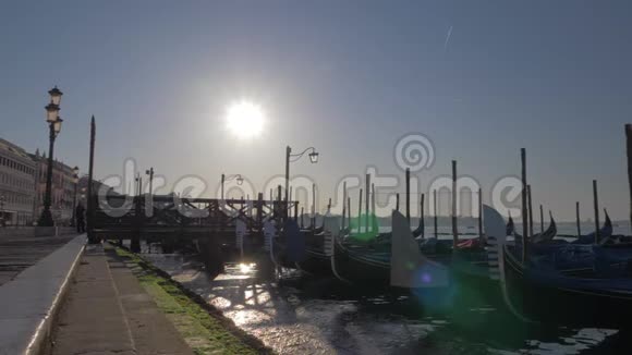 在靠近铺设好的威尼斯堤岸的码头上摇曳着一个缓缓移动的贡多拉斯视频的预览图