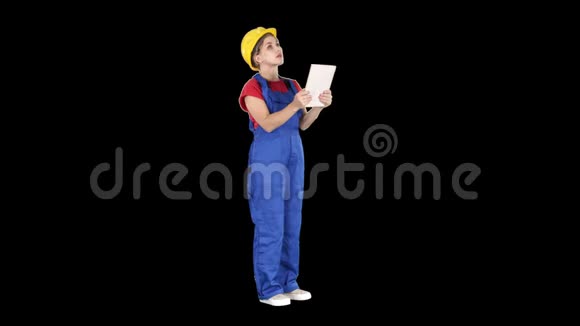 戴黄色安全帽的女工程师在检查建筑大楼时正在看平板电脑阿尔法视频的预览图
